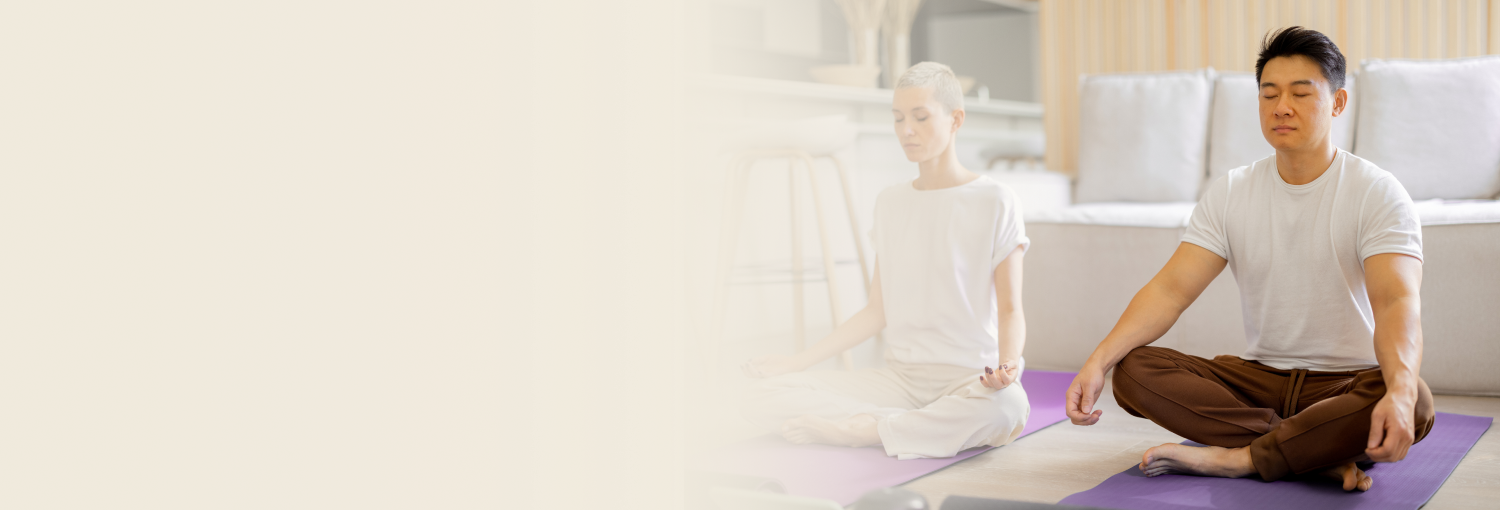Two people meditating by sitting on the yoga mat